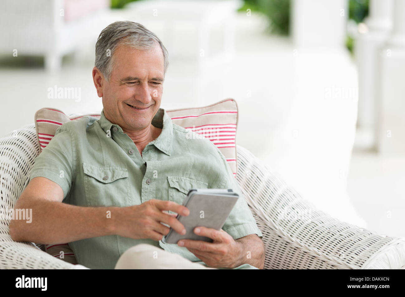 Older Man using tablet computer on porch Banque D'Images