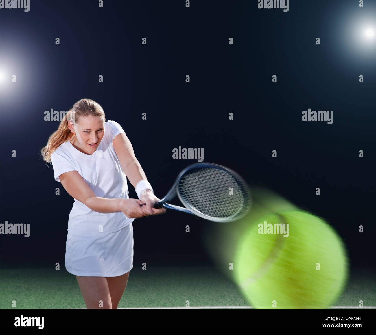 Tennis player hitting ball on court Banque D'Images
