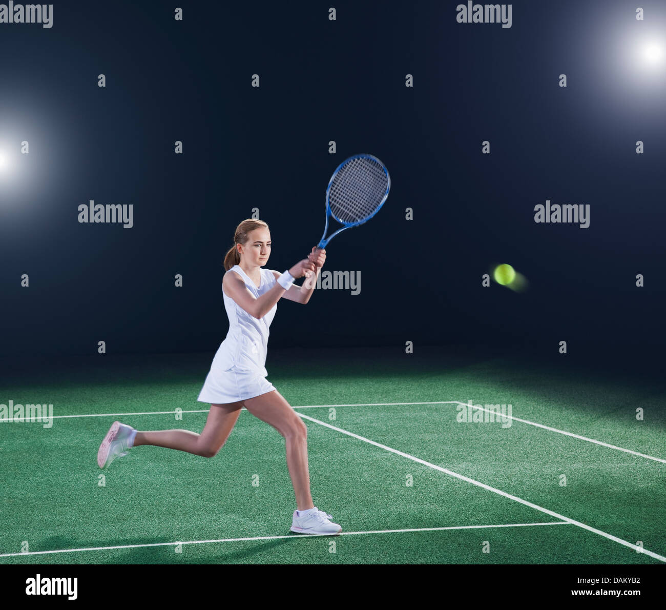 Tennis player hitting ball on court Banque D'Images