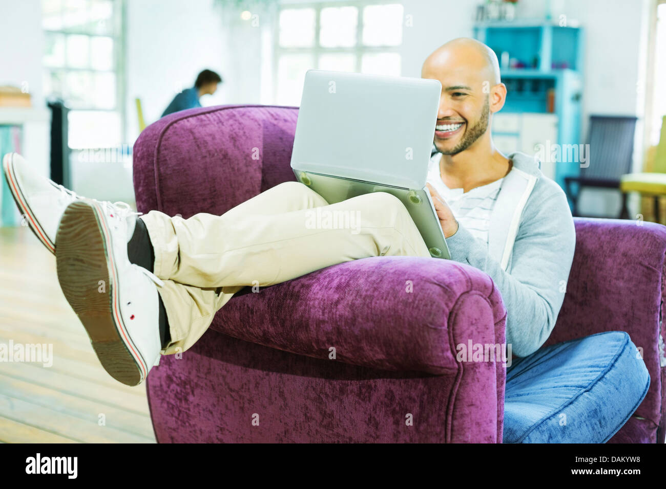 Man using laptop in armchair Banque D'Images