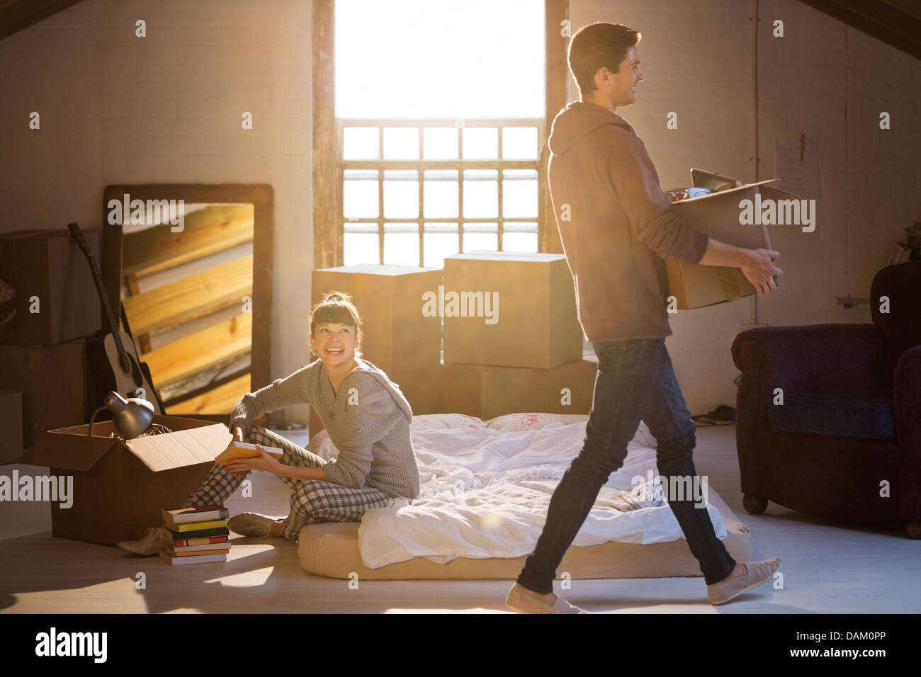 Couple unpacking boxes in attic Banque D'Images