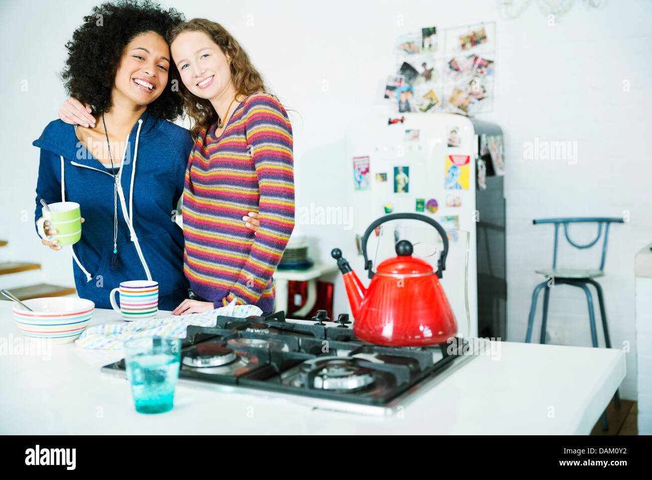 Women hugging in kitchen Banque D'Images