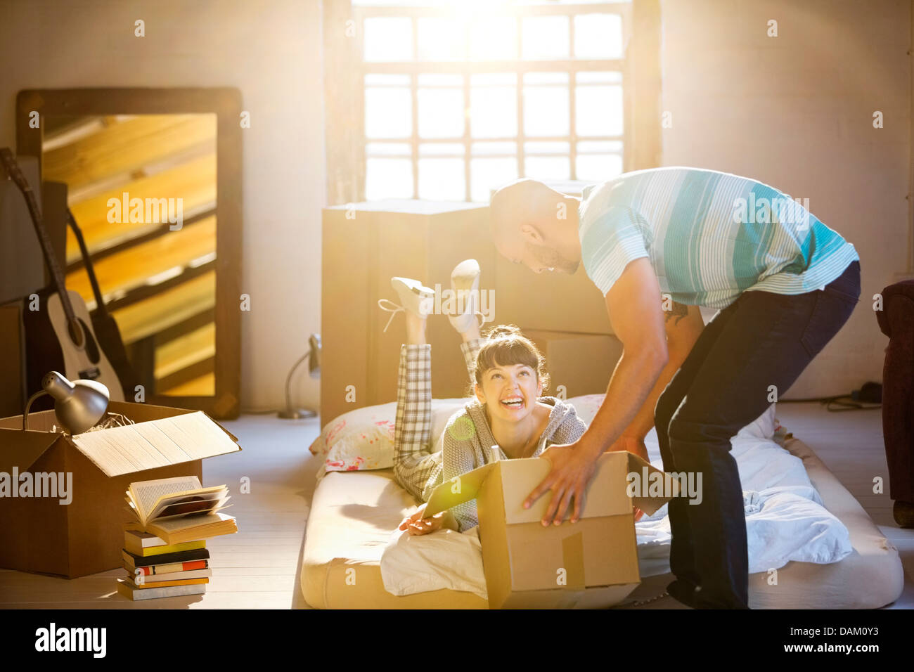 Couple unpacking boxes in attic Banque D'Images