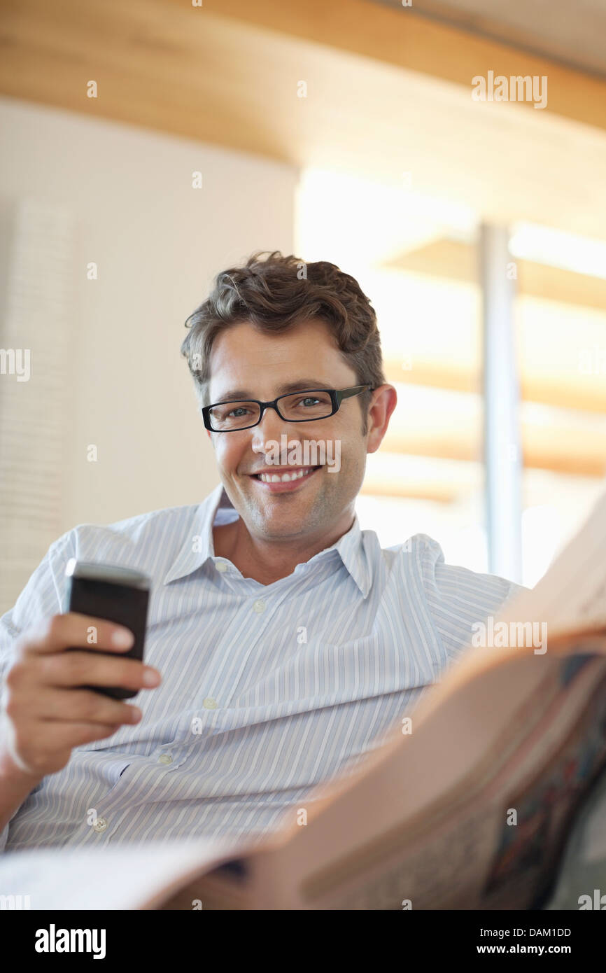 Man using cell phone on sofa Banque D'Images