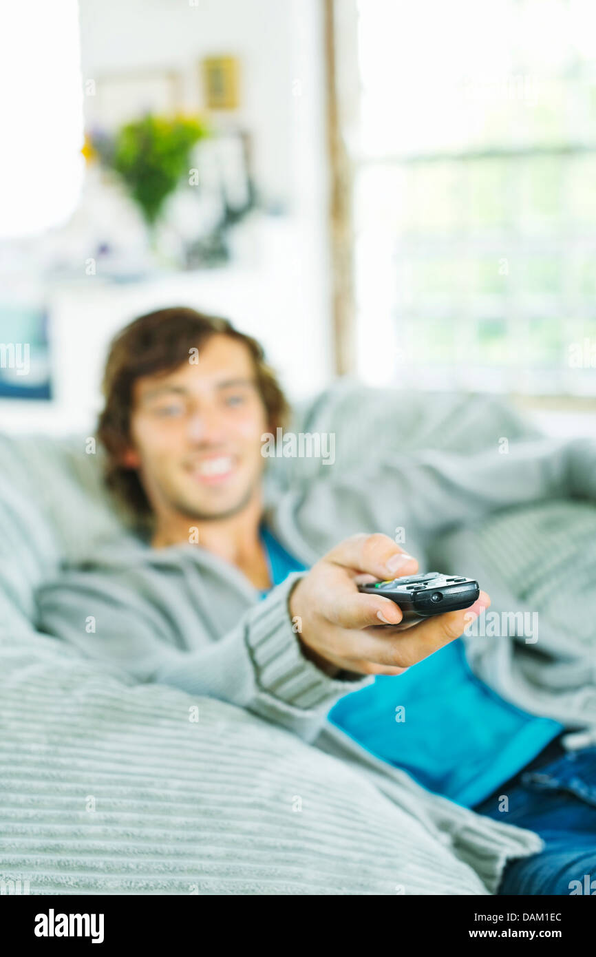 L'homme regardant la télévision en fauteuil poire Banque D'Images