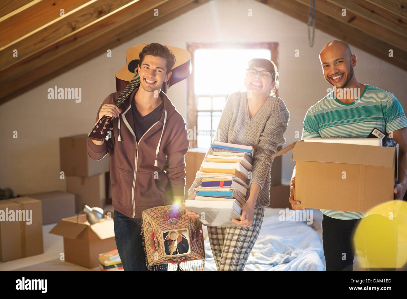 Friends unpacking boxes in attic Banque D'Images