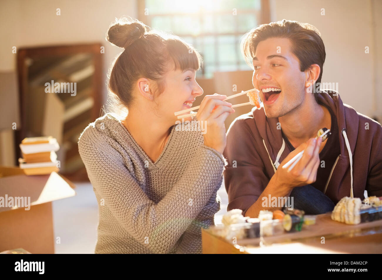 Couple eating sushi ensemble à new home Banque D'Images