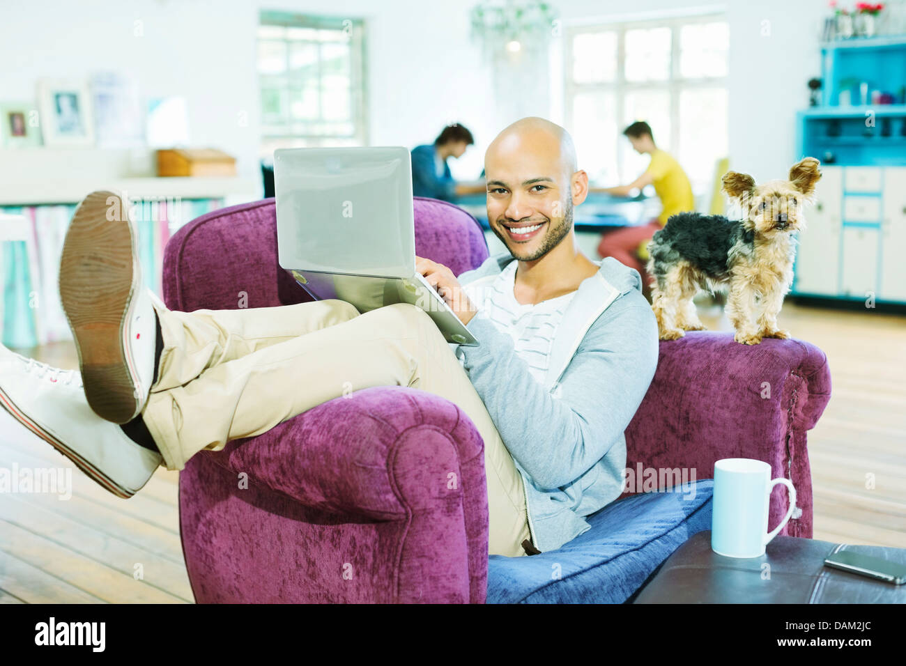 Man using laptop in armchair Banque D'Images