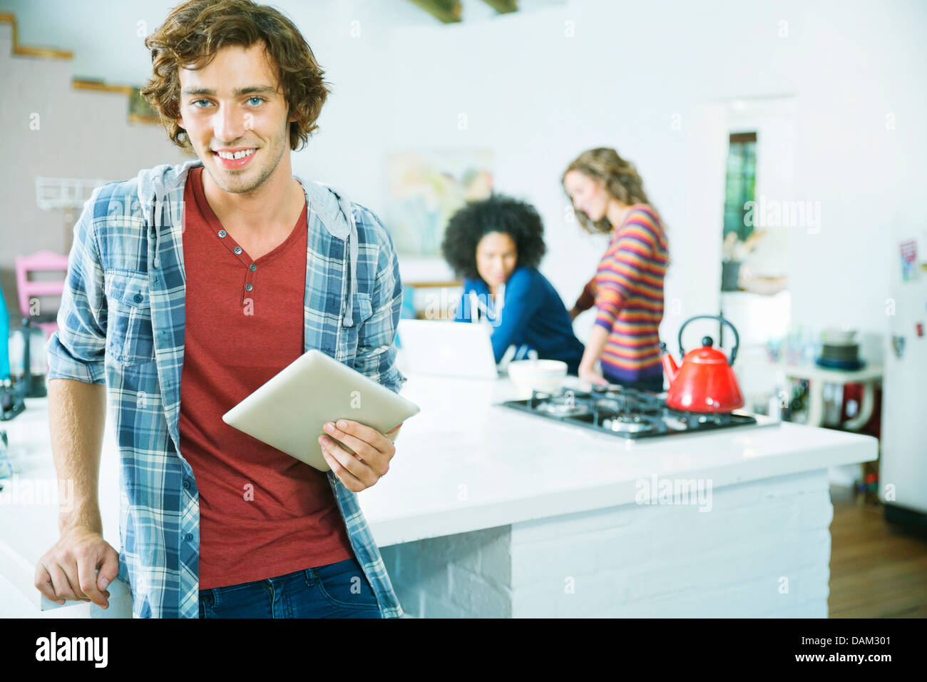 Man using tablet computer in kitchen Banque D'Images
