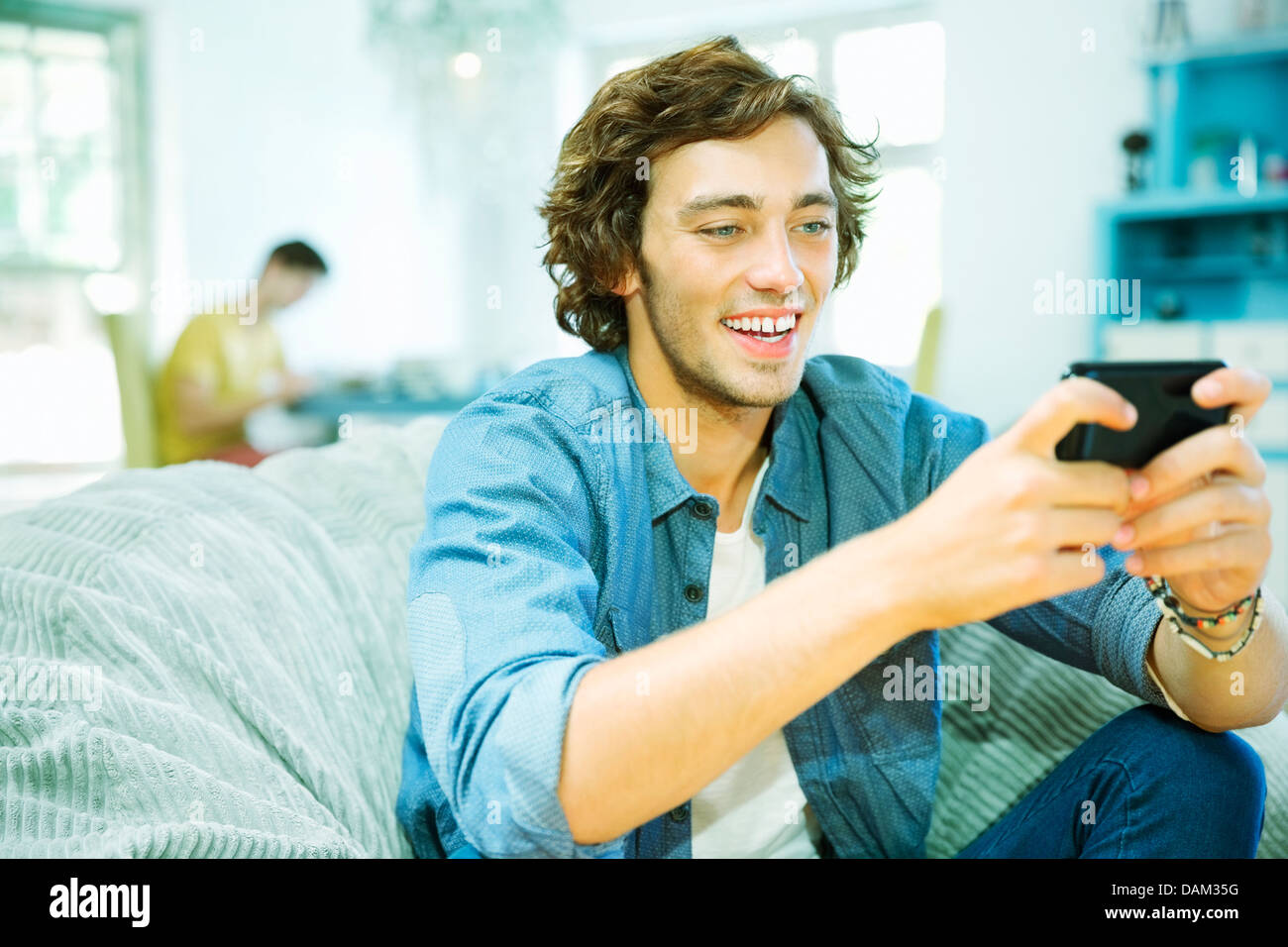 Man using cell phone in fauteuil poire Banque D'Images