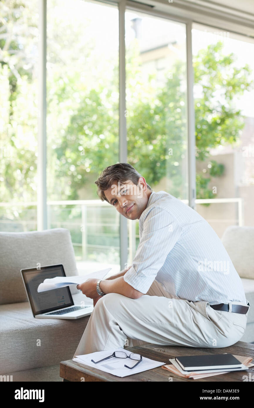 Businessman using laptop on sofa Banque D'Images