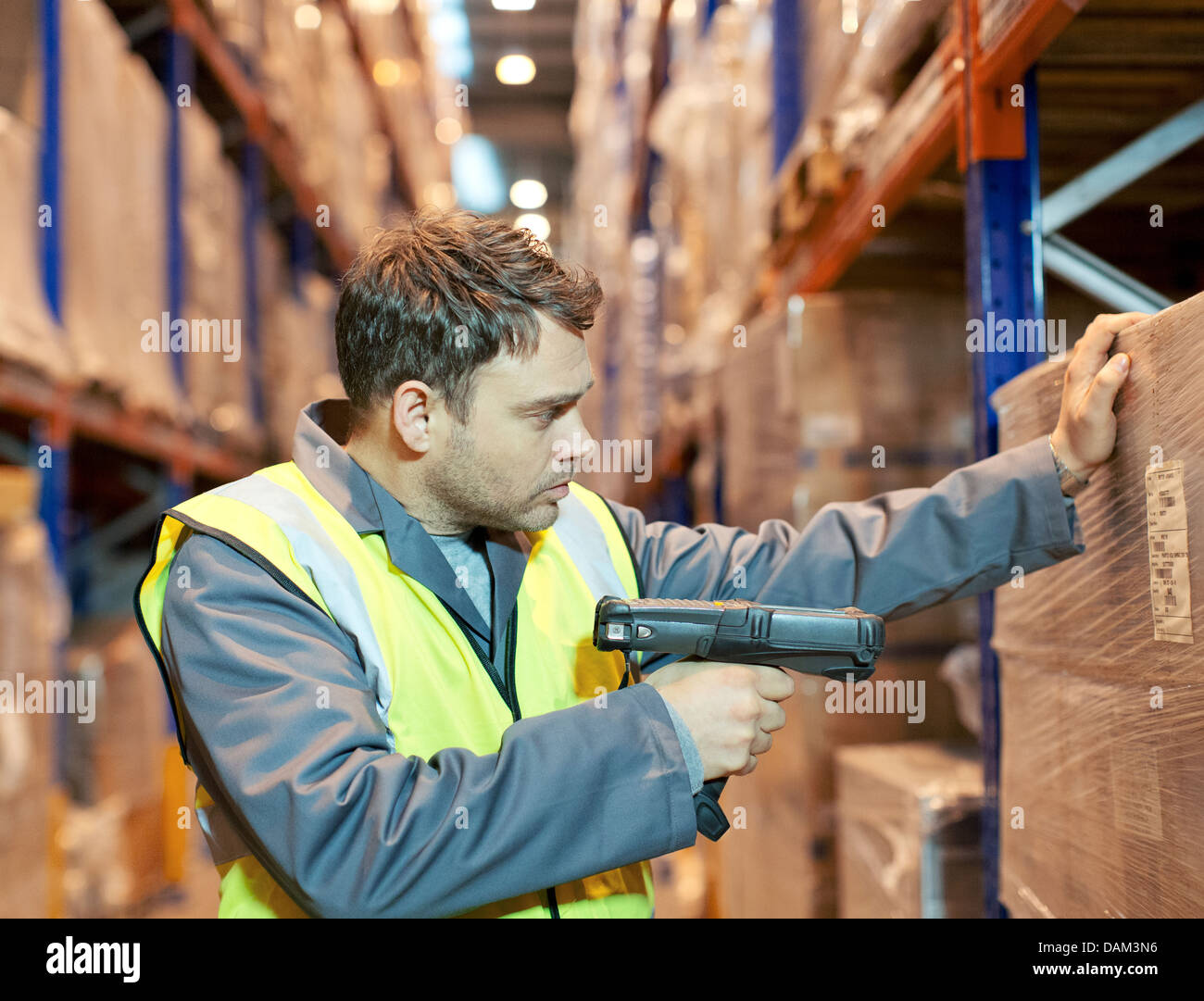 Numérisation travailleur boxes in warehouse Banque D'Images