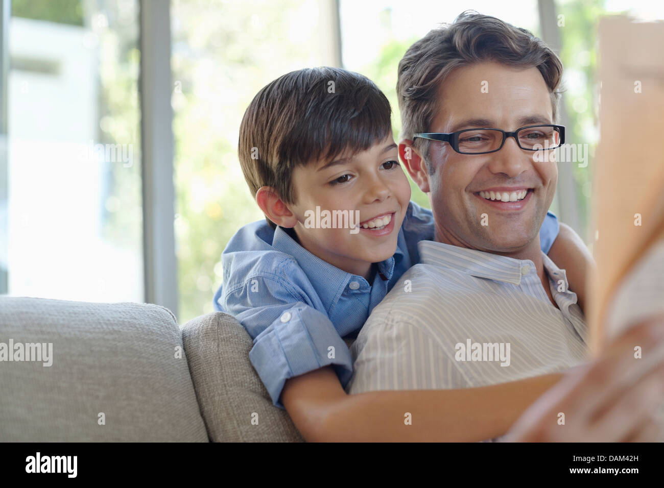 Père et fils hugging on sofa Banque D'Images
