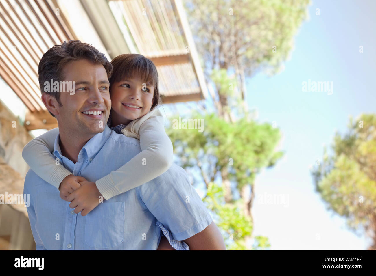 Père fille comptable piggy back outdoors Banque D'Images