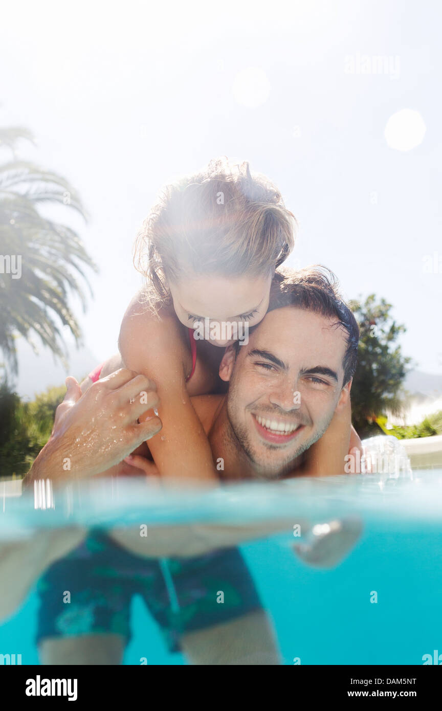 Couple playing in swimming pool Banque D'Images