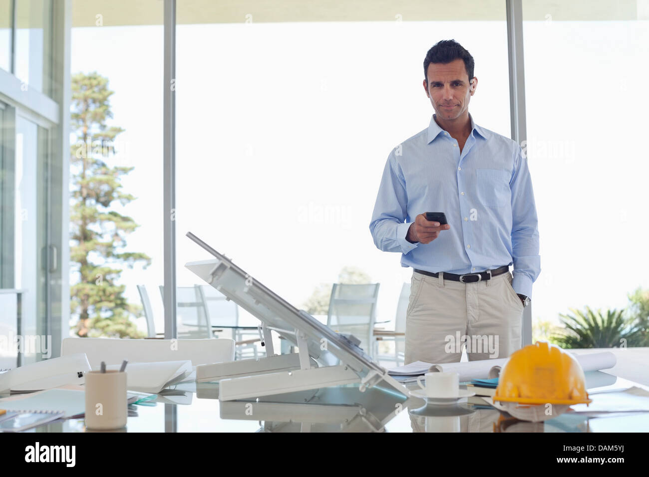 Businessman using cell phone in office Banque D'Images