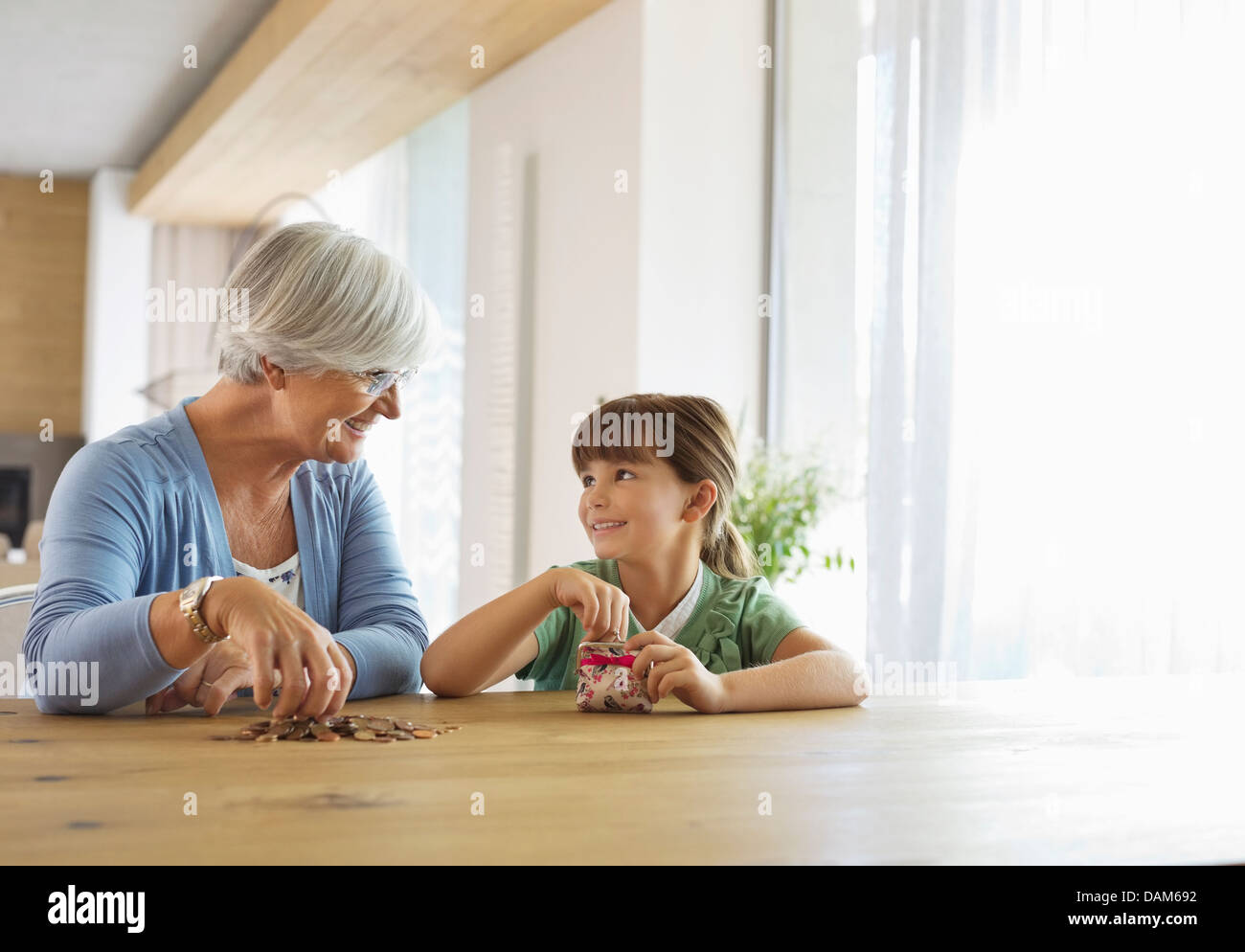 Femme plus âgée et petite-fille dragées change jar Banque D'Images