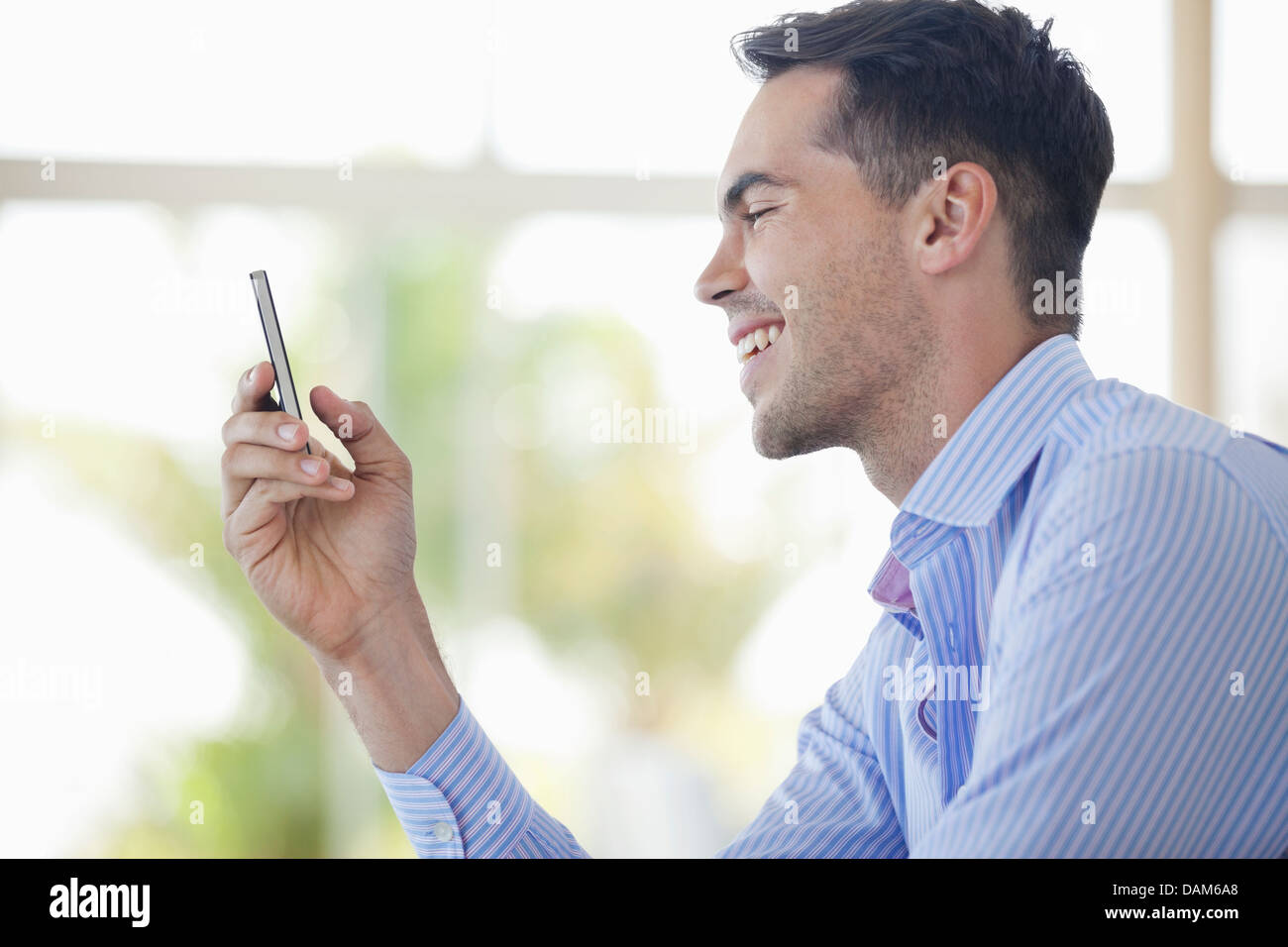 Businessman using cell phone in office Banque D'Images