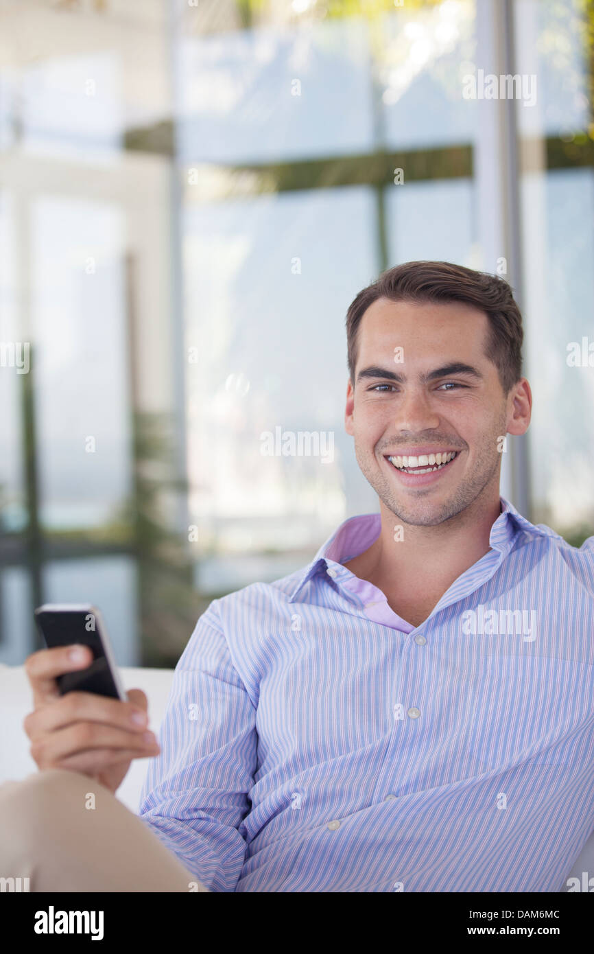 Businessman using cell phone in office Banque D'Images