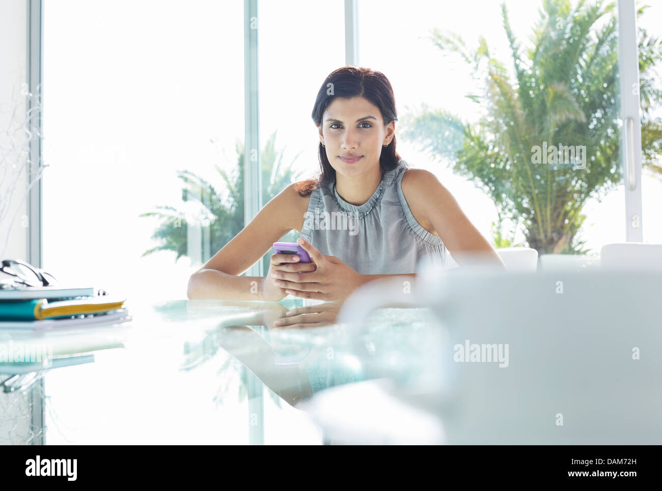 Businesswoman using cell phone in office Banque D'Images