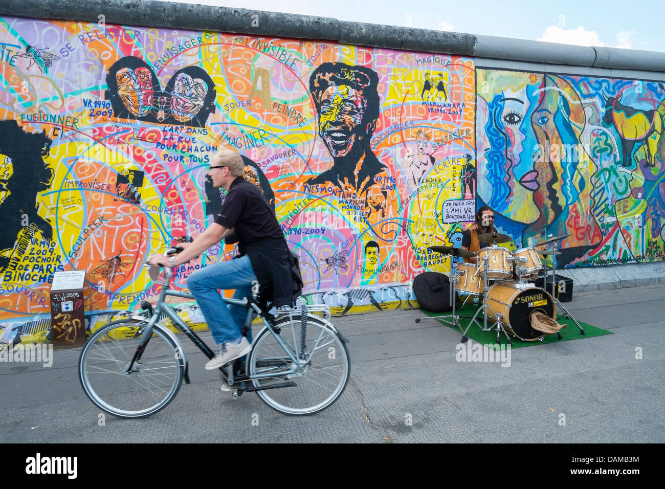 Musicien de la rue sur rue à côté mur de Berlin à l'East Side Gallery à Berlin Allemagne Banque D'Images