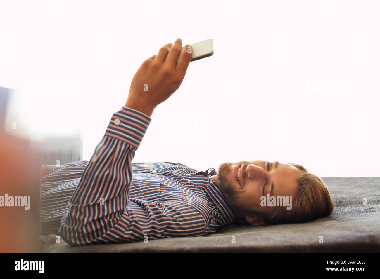 Man using cell phone on bench Banque D'Images