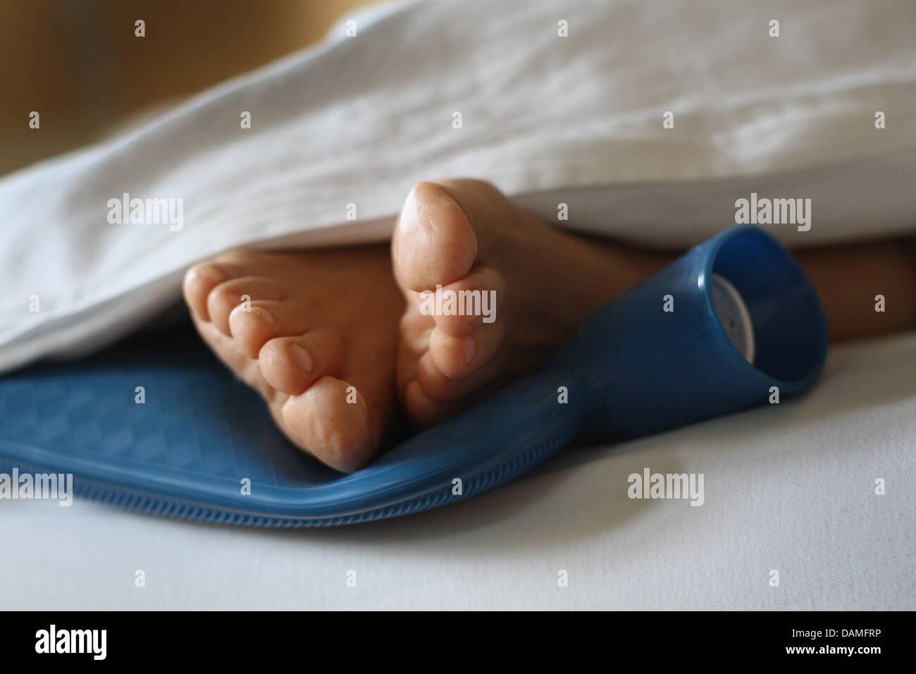 ILLUSTRATION - Les pieds d'une femme reste sur une bouteille d'eau chaude dans une couverture en Oberbeuren, Allemagne, le 8 juin 2011. Photo : Karl-Josef Opim Banque D'Images