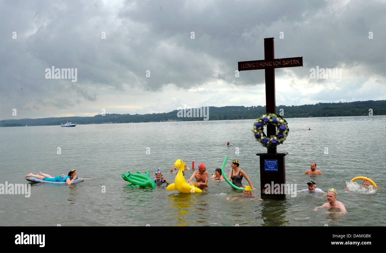 Les participants d'une manifestation de protestation organisée par le groupe "l'autre Bavaria' nager avec des couronnes et des flotteurs au King Ludwig II memorial crosson à l'occasion du 125e anniversaire du roi Louis II de Bavière dans le lac Starnberger la mort à Berg, Allemagne, 16 juin 2011. Le roi Louis II a été trouvé mort à cet endroit il y a 125 ans. Anti-monarchistes se moque de la Ludwig remembranc Banque D'Images