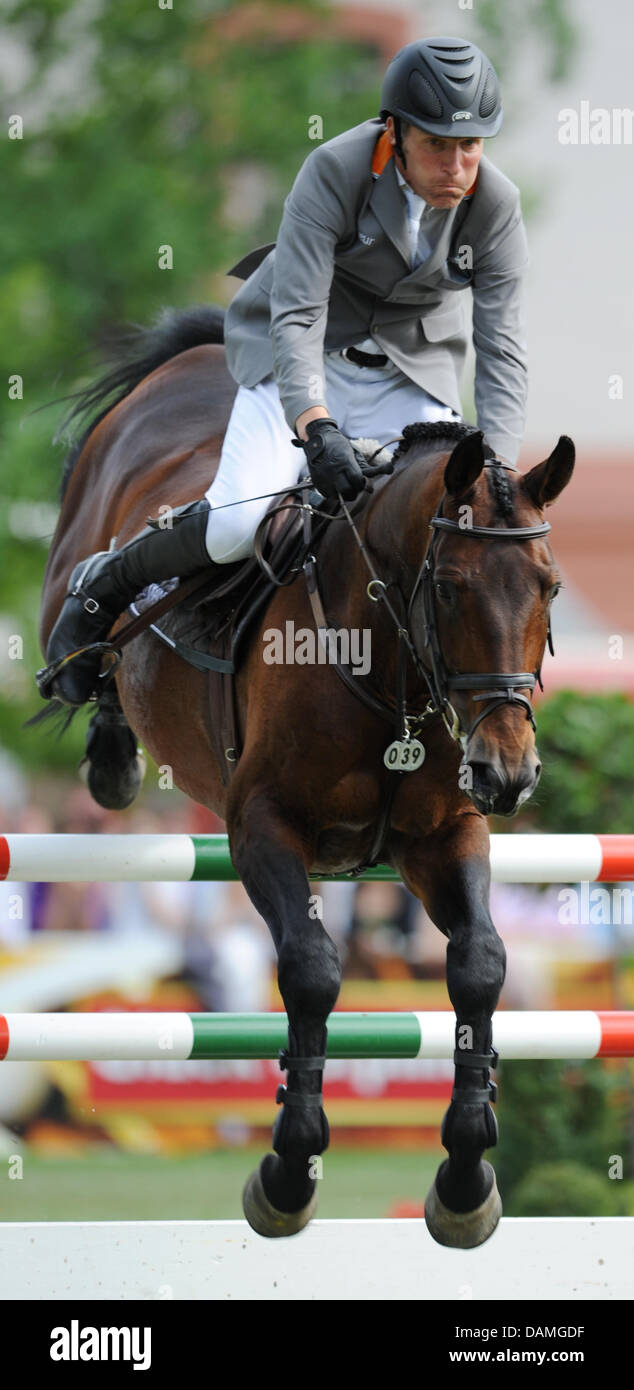 Ludger Beerbaum saute par dessus un obstacle sur son cheval Chaman au cours du deuxième tour de la Grosser Preis (grand prix) à la Pentecôte horse show à Wiesbaden, Allemagne, 13 juin 2011. Il a remporté le prix de 75 000 euros pour le saut avec un temps de 46,38 secondes et 0 points de démérite. Photo : ARNE DEDERT Banque D'Images