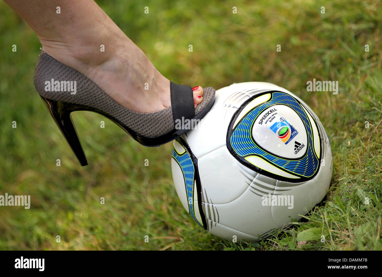 Une femme dans une chaussure à talon haut se dresse sur un ballon de  football à Berlin, Allemagne, 22 juin 2011. L'équipe féminine de soccer  jouera contre le Canada dans le match