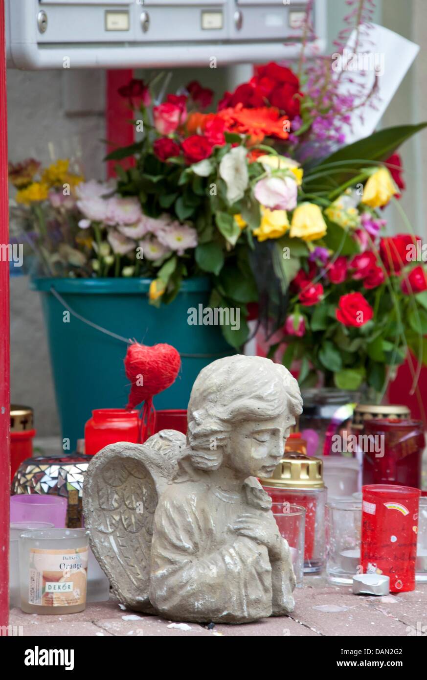Des fleurs, des bougies et la statue d'un ange sont mis en place à Mary-Jane's home à Radolfzell, Allemagne, 05 juillet 2011. Le 24 juin 2011, l'enfant de sept ans n'a pas renvoyé de l'école. Les randonneurs a trouvé son corps à un ruisseau dans la forêt. Le 07 juillet, un service commémoratif a prévu de faire le deuil de la fille. Photo : Michael Reichel Banque D'Images