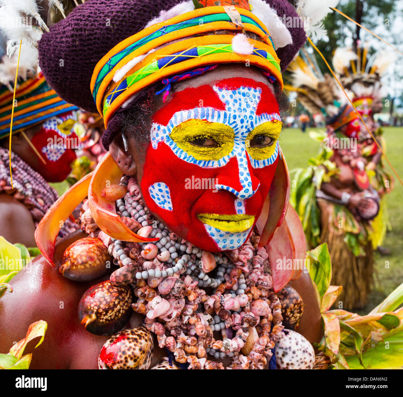 Femme Tribal avec son visage peint de couleurs vives et portant un collier de coquillages au festival de Goroka en Papouasie Nouvelle Guinée Banque D'Images