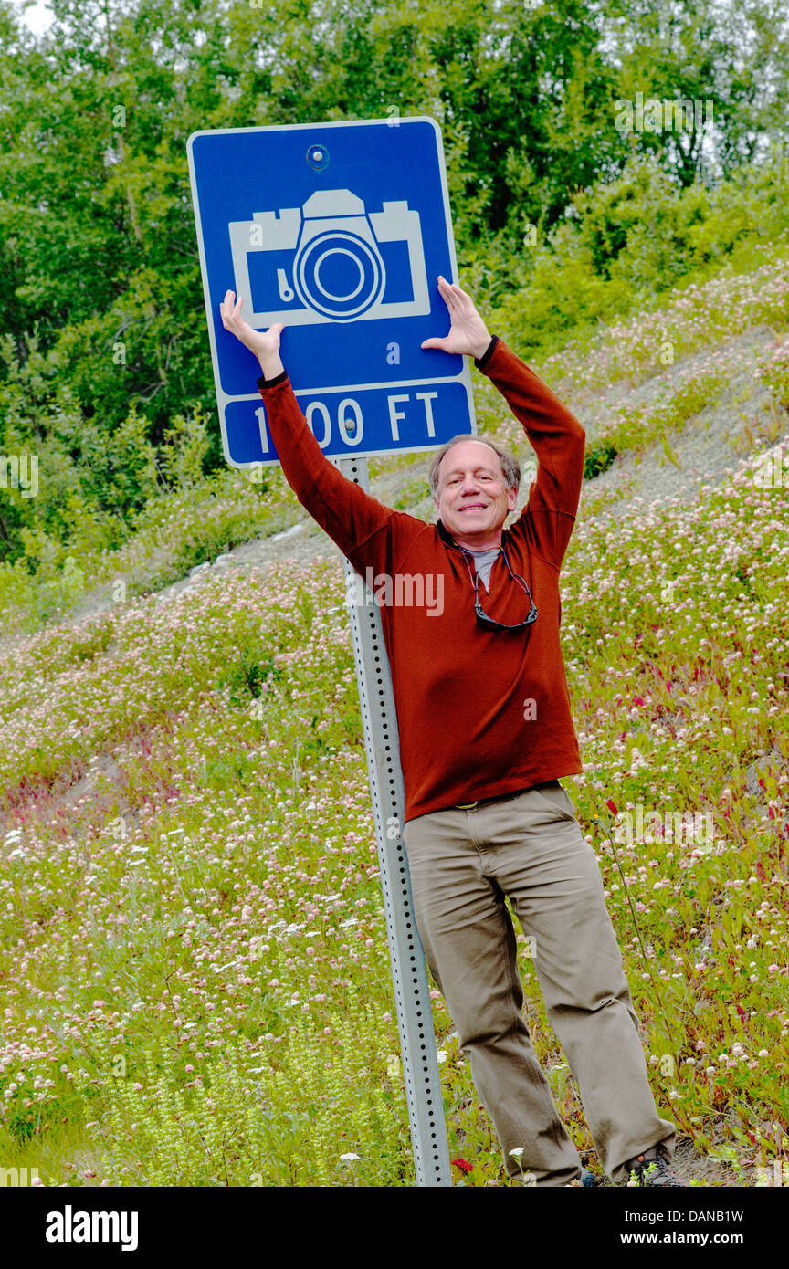 H. Photographe Mark Weidman et un panneau routier indiquant l'icône Appareil photo photo panoramique view point, Autoroute Glen ; route 1, Alaska USA Banque D'Images