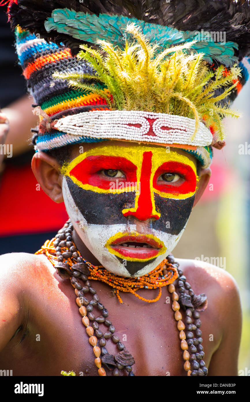 Jeune garçon avec son visage peint et portant un couvre-chef tribal à l'Goroka show dans les hautes terres de la Papouasie-Nouvelle-Guinée Banque D'Images