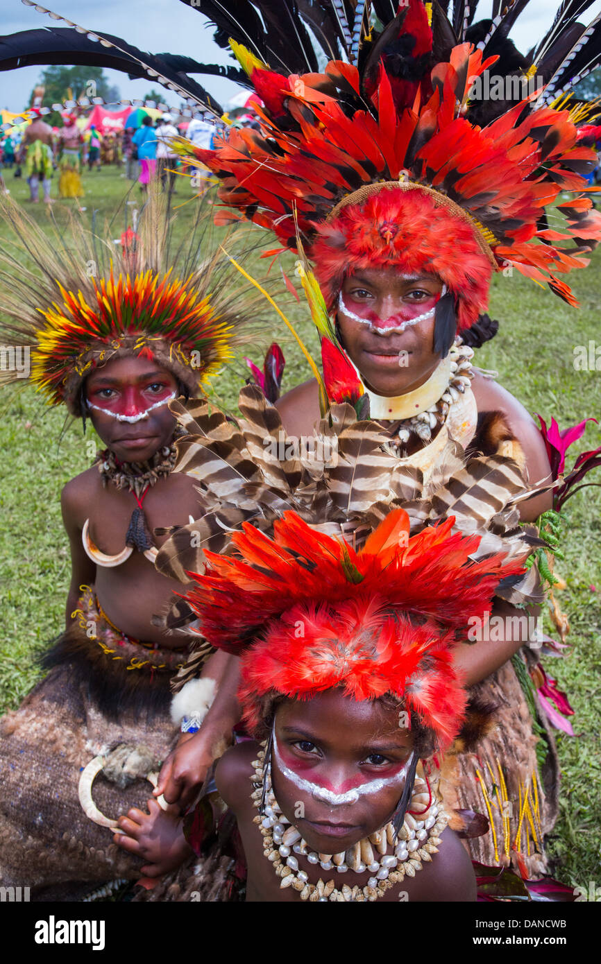 Femme et enfants chaque portant un couvre-chef en plumes, vêtus de costumes traditionnels tribaux, Goroka show, Papouasie Nouvelle Guinée Banque D'Images