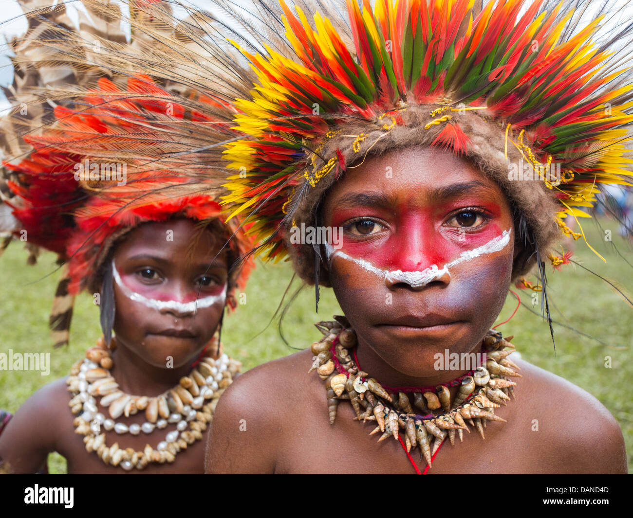 Enfants portant une coiffe de plumes de couleur vive faite de plumes, lorikeet Goroka show, Papouasie Nouvelle Guinée Banque D'Images