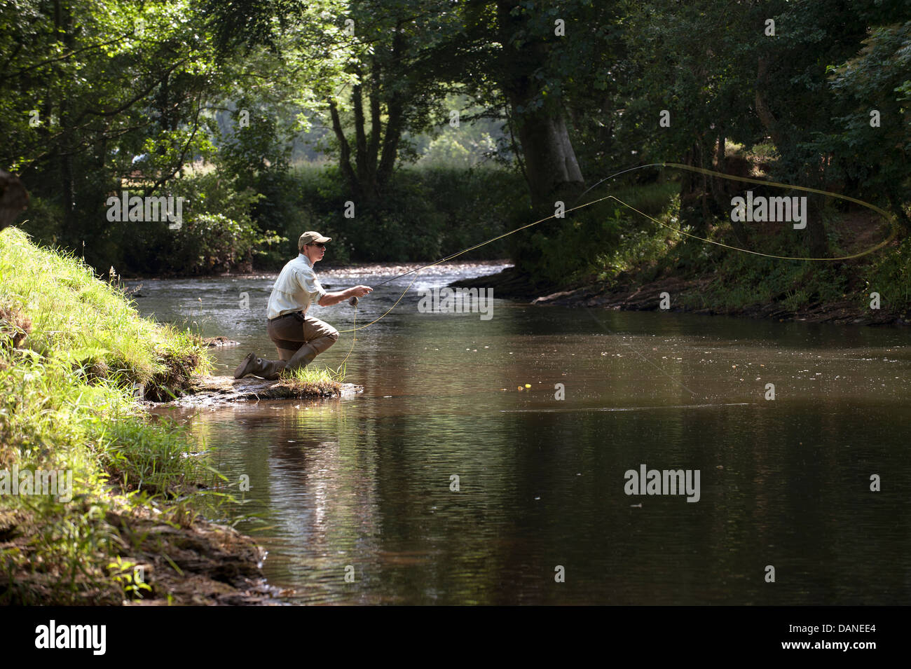L'homme pêche de mouche sur la rivière dans le Devon, Angleterre Royaume-uni Lyd Banque D'Images