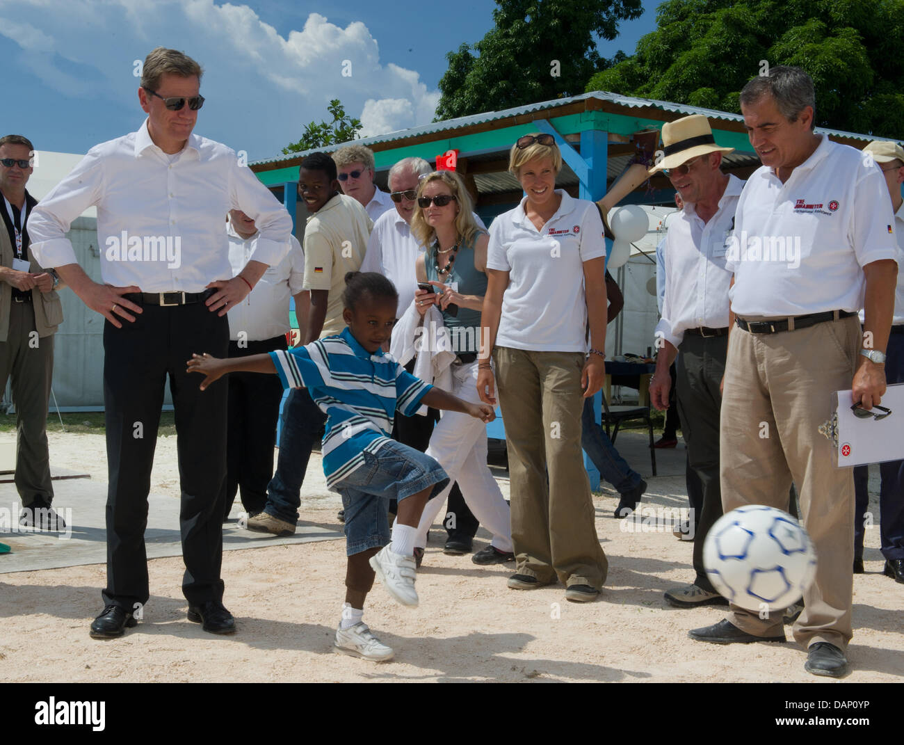 Le ministre des Affaires étrangères allemand Guido Westerwelle (L) joue au soccer avec un garçon avec une prothèse de jambe à l'aide de l'organisation Johanniter LÉOGÂNE, Haïti, 17 juillet 2011. La visite de l'état des Caraïbes est Westerwelle's dernier arrêt de sa tournée à travers l'Amérique latine. Photo : Soeren Stache Banque D'Images