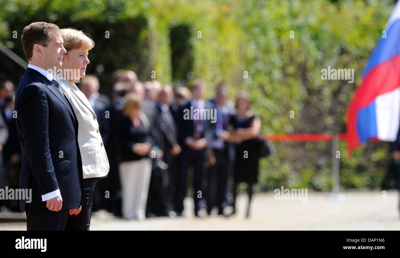 Le président russe Dmitri Medvedev (G) et la chancelière allemande, Angela Merkel, prendre part à l'honneurs militaires au cours de la consultation du gouvernement russe à l'Herrenhaus gardens à Hanovre, Allemagne, 19 juillet 2011. Photo : CAROLINE SEIDEL Banque D'Images