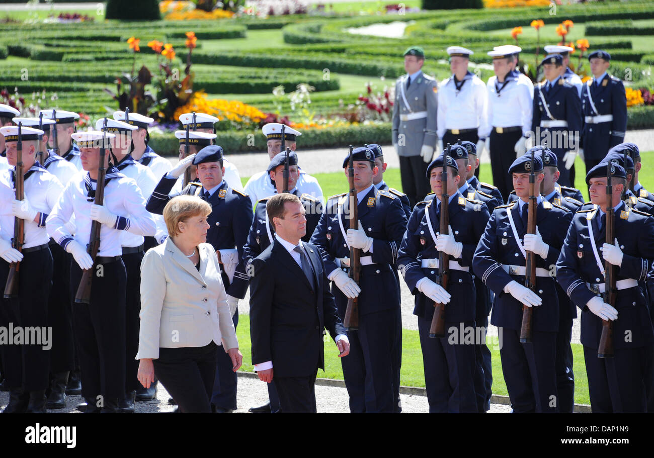 Le président russe Dmitri Medvedev (R) et la chancelière allemande, Angela Merkel, prendre part à l'honneurs militaires au cours de la consultation du gouvernement russe à l'Herrenhaus gardens à Hanovre, Allemagne, 19 juillet 2011. Photo : CAROLINE SEIDEL Banque D'Images