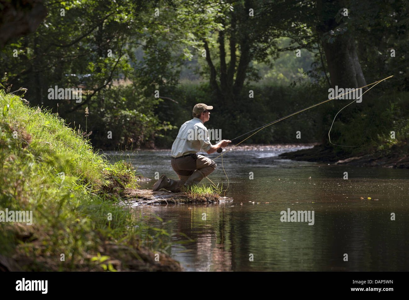 L'homme pêche de mouche sur la rivière dans le Devon, Angleterre Royaume-uni Lyd Banque D'Images