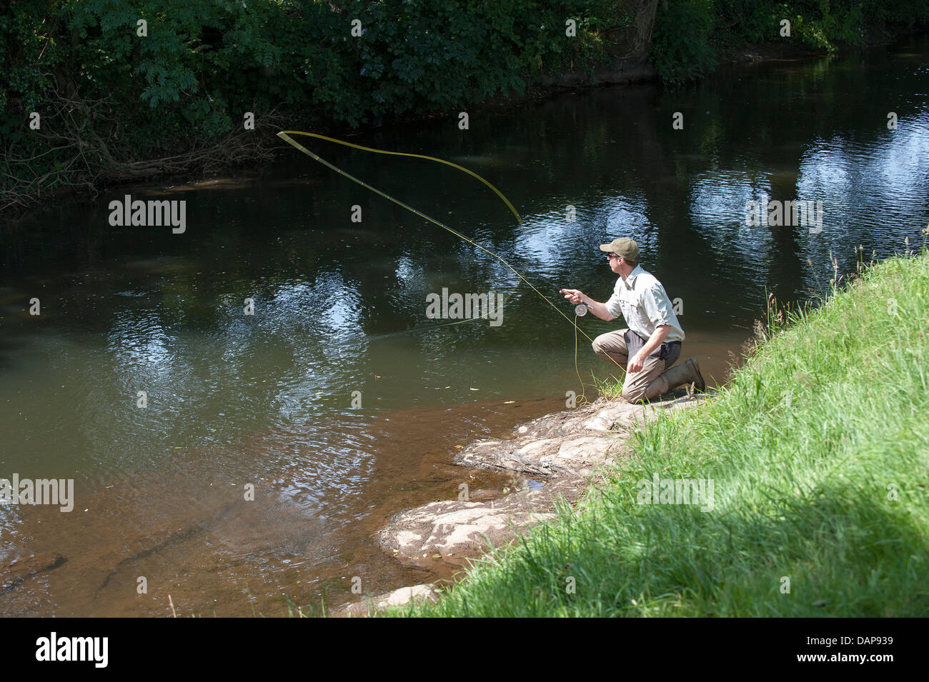 L'homme pêche de mouche sur la rivière dans le Devon, Angleterre Royaume-uni Lyd Banque D'Images
