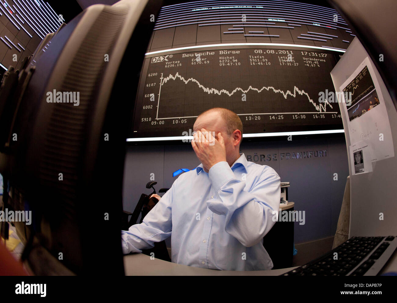 Un courtier couvre son visage avec ses mains à la bourse de Francfort, Allemagne, le 8 août 2011. Le déclassement de l'USA a largement influencé l'évolution de la bourse. Photo : Frank Rumpenhorst Banque D'Images