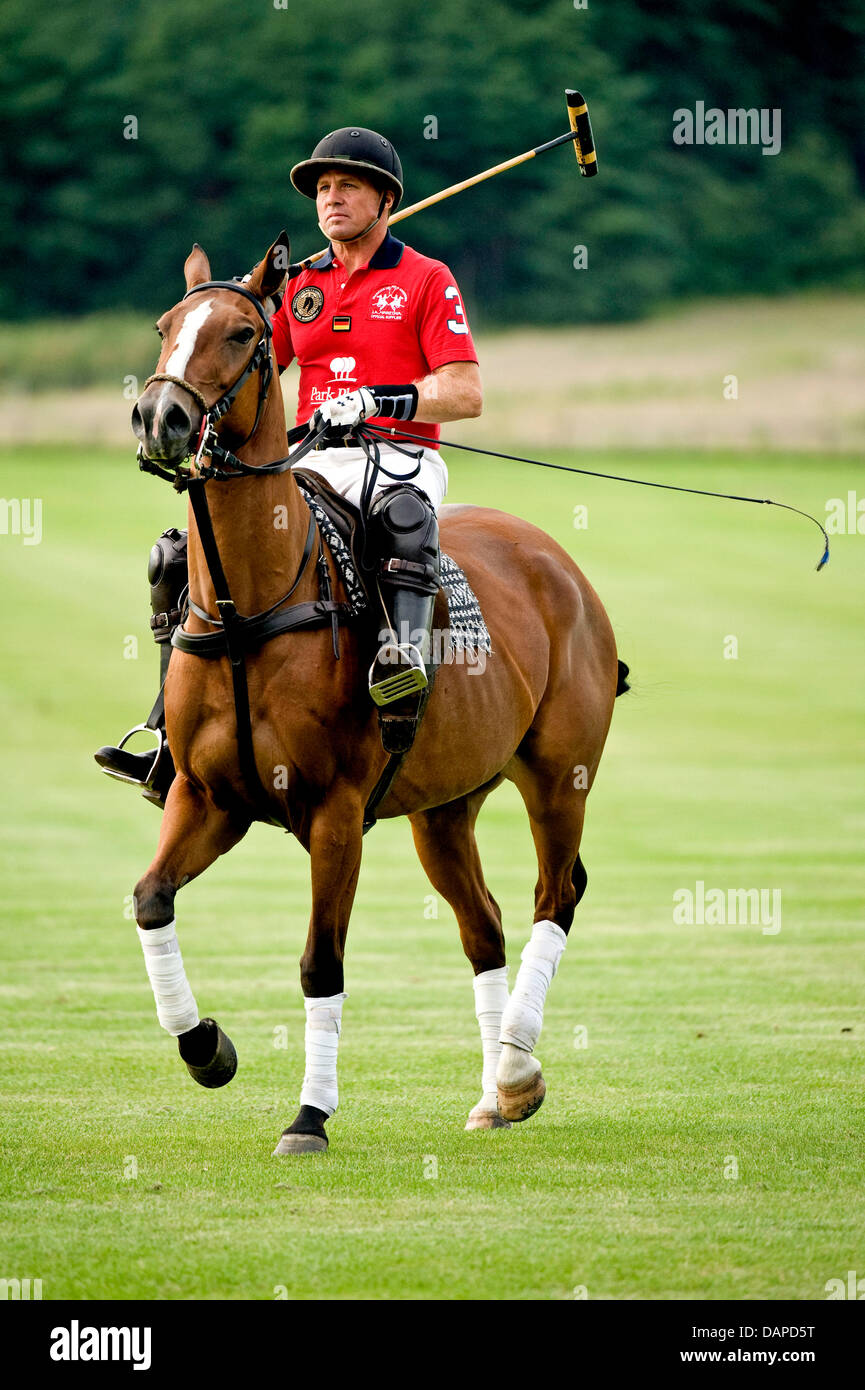 USA's polo sportif Mike Azzaro repose sur un cheval de polo à travers un  terrain de polo en Phoeben, Allemagne, 10 août 2011. Le championnat  allemand polo 'Objectif' aura lieu du 10