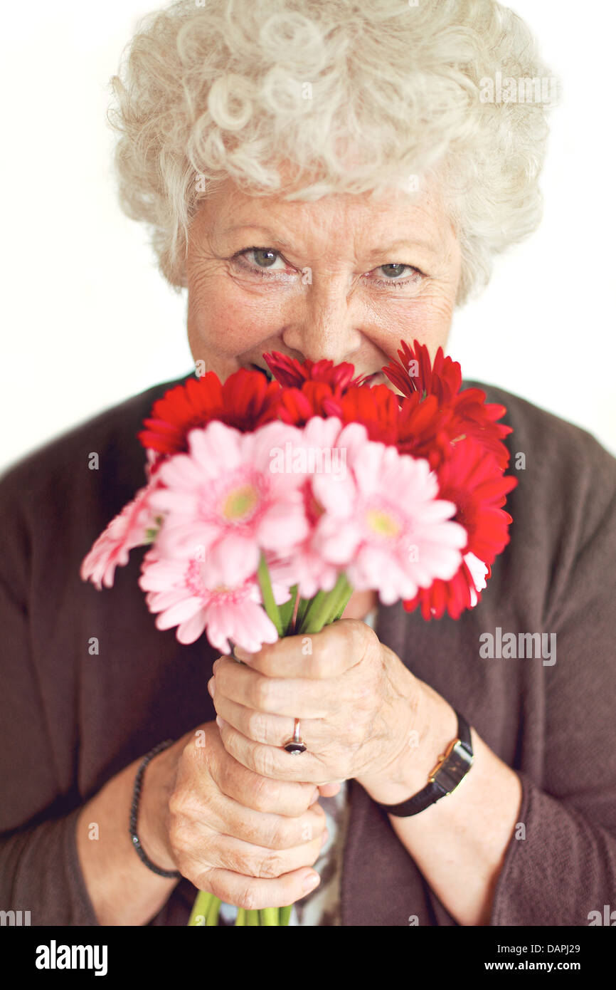 Grand-mère joyeuse heureuse d'avoir reçu des fleurs le jour de la mère Banque D'Images