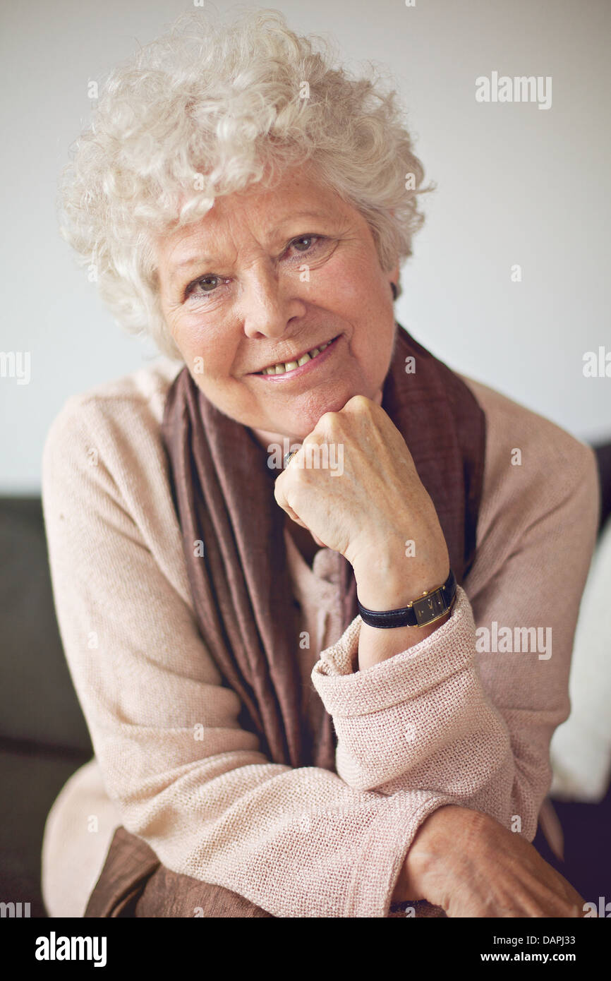 Closeup of a senior woman sitting at home et regardant la caméra Banque D'Images
