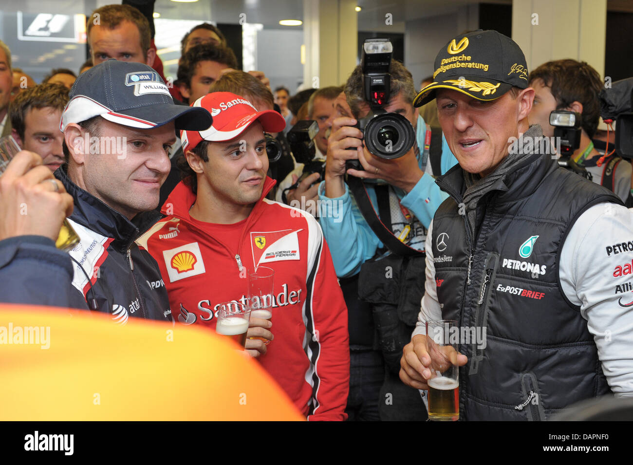 Rubens Barrichello brésilienne (L - R) de Williams, le Brésilien Felipe Massa, de Ferrari et l'Allemand Michael Schumacher Mercedes GP d'avoir une bière Kölsch' 'ensemble à Schumachers anniversaire party dans la Mercedes GP camping au circuit de Spa-Francorchamps près de Spa, Belgique, 27 août 2011. Au GP de Belgique 1991 Michael Schumacher a conduit sa première course de Formule 1 - 20 ans lat Banque D'Images