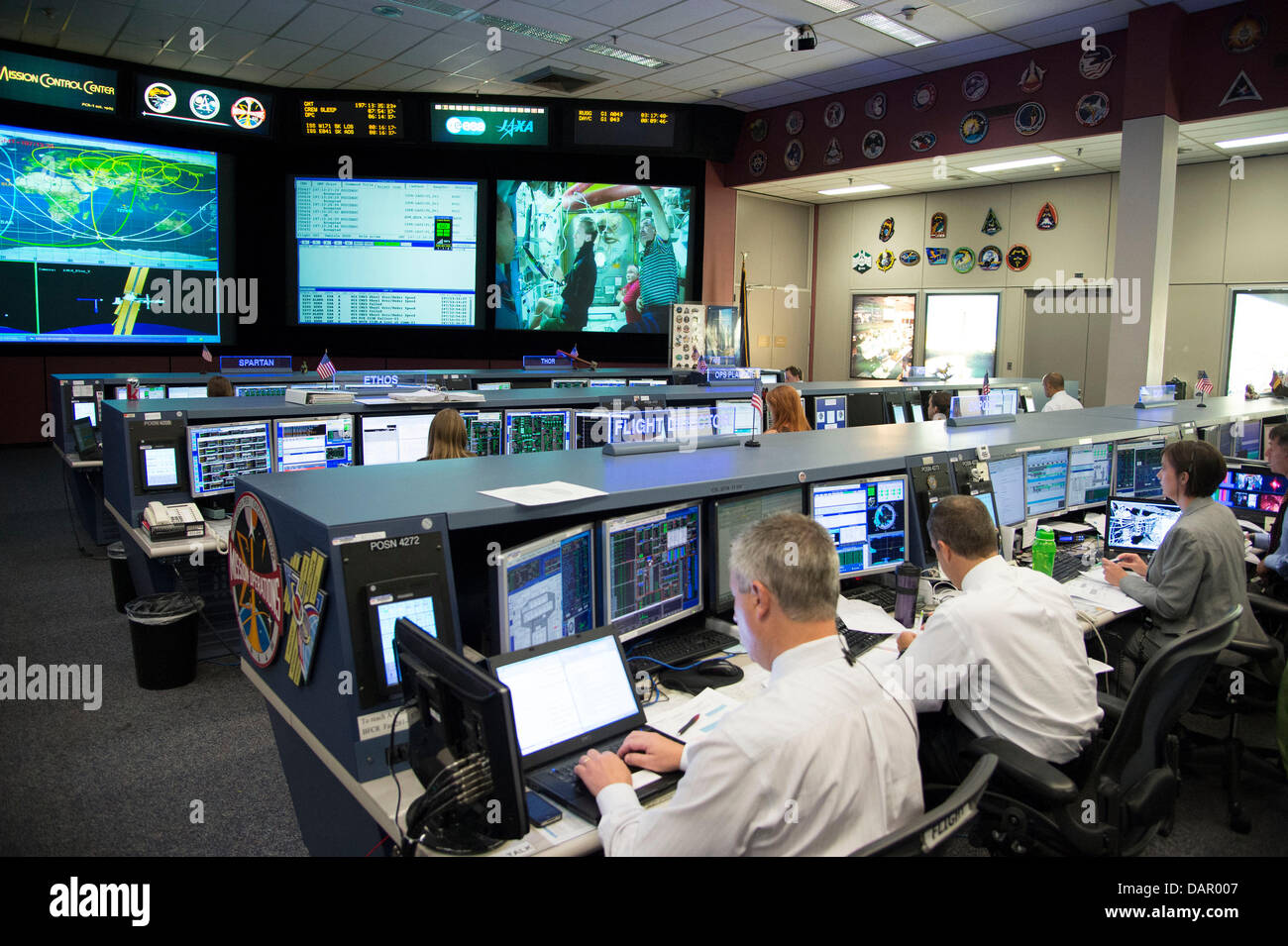 Les directeurs de vol et d'engins spatiaux de la communication apparaissent dans l'avant-plan de cette scène dans la salle de contrôle de vol de la station spatiale du Johnson Space Center, Centre de contrôle de mission au cours de la sortie dans l'expédition de 36 astronautes Chris Cassidy de la NASA et Luca Parmitano de l'Agence spatiale européenne le 16 juillet 2013 à Houston, TX. Problèmes avec l'Parmitano spacesuit a la sortie dans l'espace d'une fin. Banque D'Images