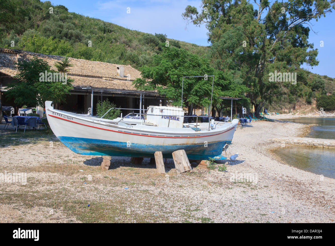 Vieux bateau à vendre avec signe devant le restaurant Eucalyptus à Agios  Stephanos Corfu Photo Stock - Alamy