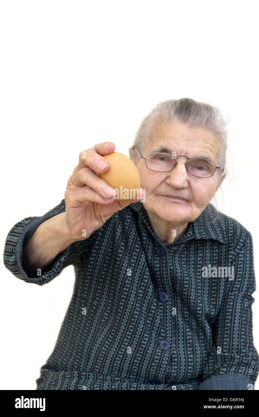 Vieille Femme tenant un œuf biologique. Selective focus sur l'oeuf. Banque D'Images